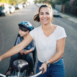 Woman riding a bike with a young boy